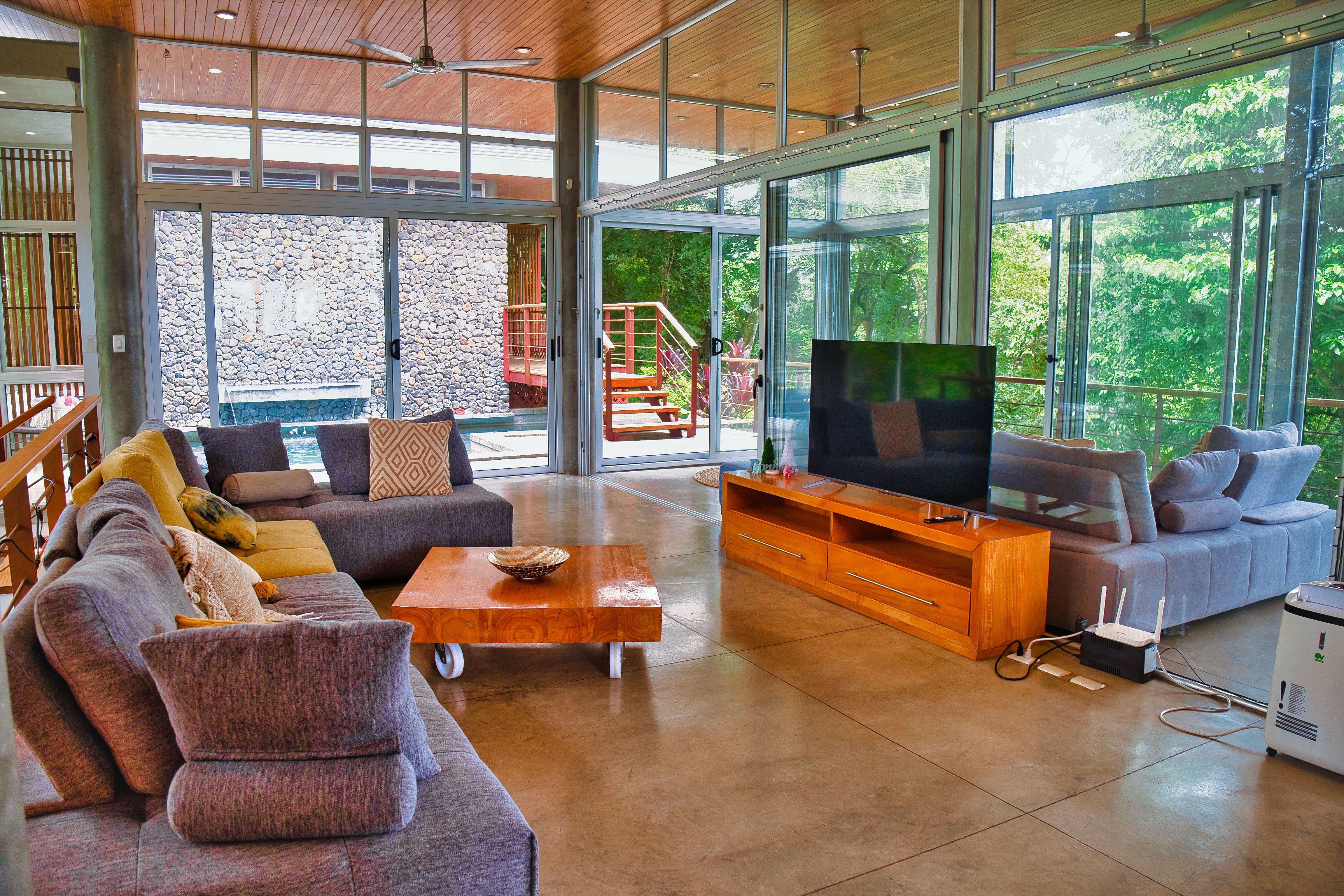 Casa Manifesting Sala de estar Nosara Costa Rica sala de estar moderna con ventanas panorámicas a la selva casa manifesting nosara costa rica